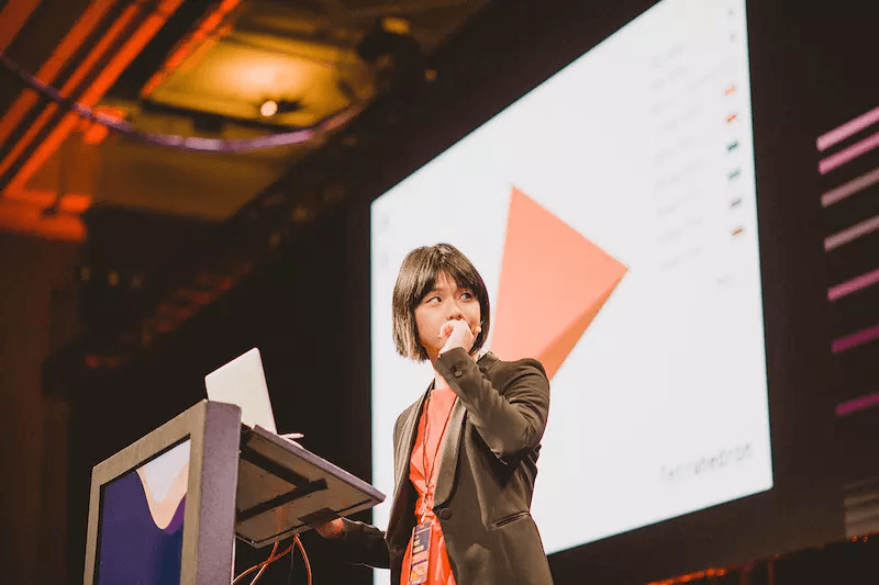 A speaker sharing ideas at a React event